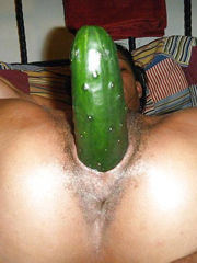 Her black pussy is filled with a huge cucumber